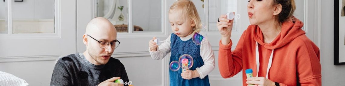 Family enjoying quality time blowing bubbles indoors, capturing joyful moments.